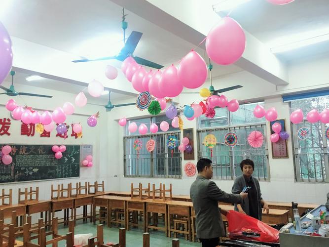 教室经过家长和小同学们的精心布置挂满彩色的气球把教室装饰得非常