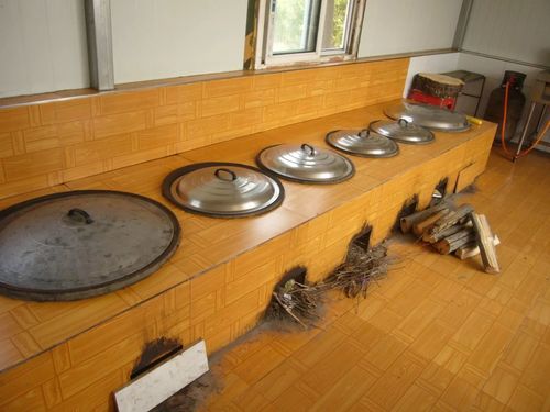 农家院的厨房是用柴火做燃料的老式灶台.
