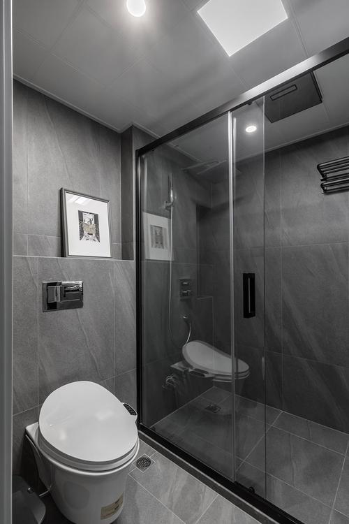 灰色的墙砖与地砖为卫生间提供了静谧卫生的空间.