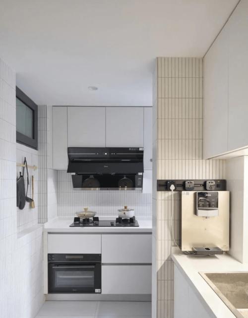 白色橱柜和台面搭配灰色地砖黑色厨电加以点缀.