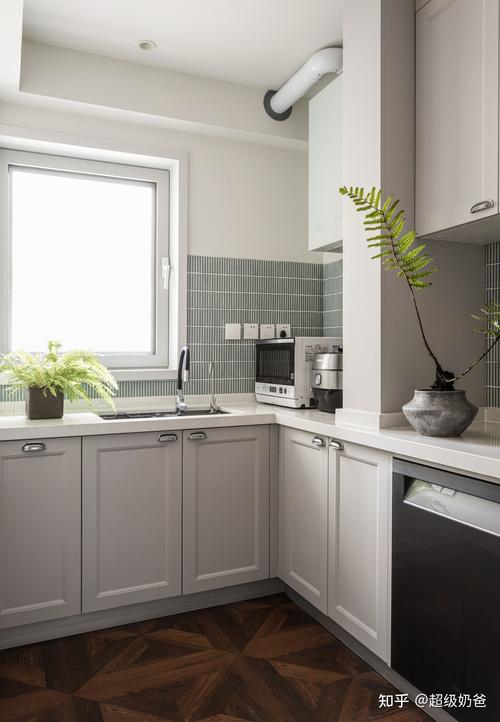 改造后的厨房是一个长方形空间定制的橱柜选择了经典的柔灰色斜切