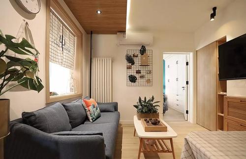 小小的客厅用白色和原木色搭配特别温暖舒适另外点缀一些绿色植物