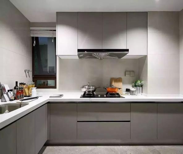 厨房内部用灰色调的柜子和地砖来搭配白色的墙面台面.