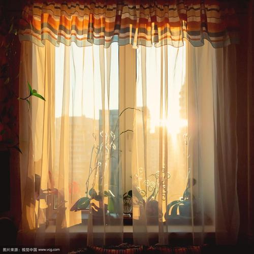 早晨的阳光透过窗帘照进窗户