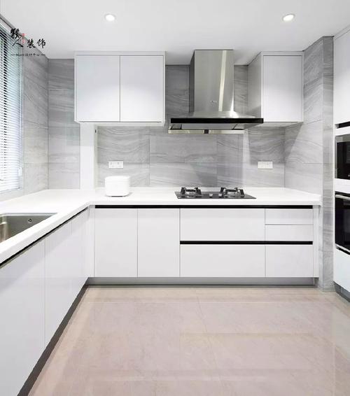 厨房墙面采用灰色纹理感墙砖搭配白色橱柜门与台面的设计给人清爽