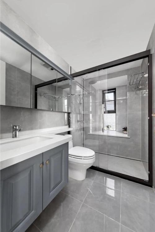 卫生间采用灰色的地砖搭配蓝灰色的浴室柜采光极佳是难得的空间