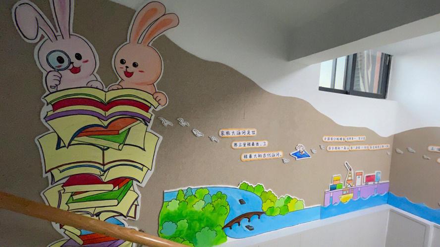 幼儿园是书香文化主题的楼梯墙面设计了幼儿园主题公仔小兔子看绘本