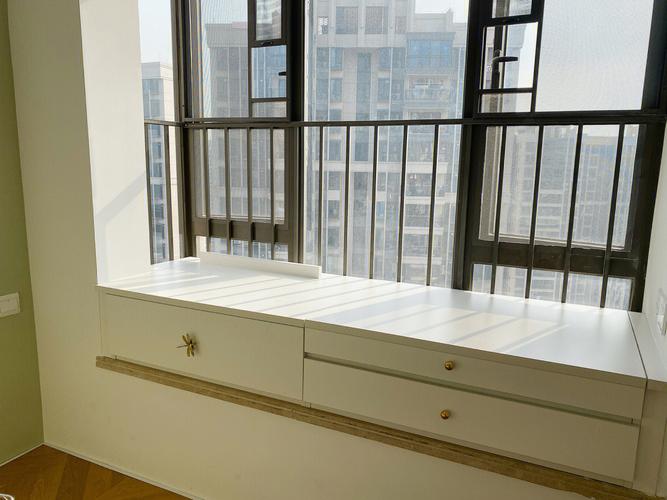 在飘窗上做了个柜子一半做抽屉一半做成抽拉台面可以当书桌也可以