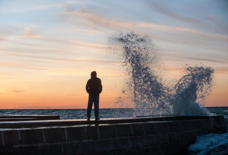 一个男人站在旁边的水身体与水溅在日落的时候轮廓高清壁纸