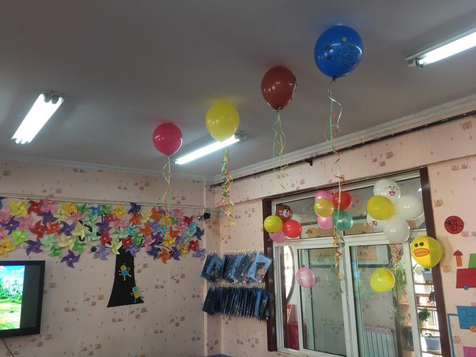 小班宝宝们和老师们一起用五颜六色的气球和漂亮的彩带装饰教室.