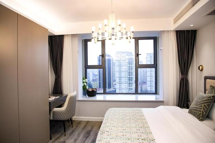 透过卧室的窗户可以领略上海的都市风情视野非常开阔暖色的吊灯与