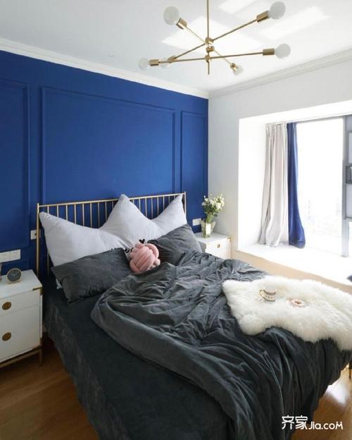 深蓝色的床头背景墙吸引了人的视线.