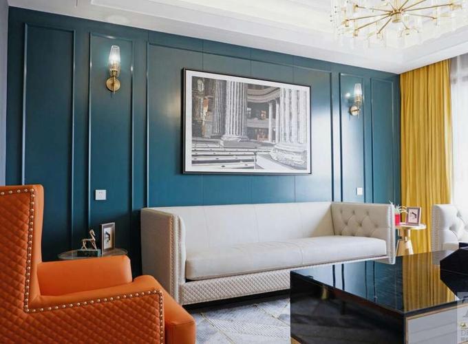 沙发背景墙整体采用孔雀蓝的护墙板作为背景色