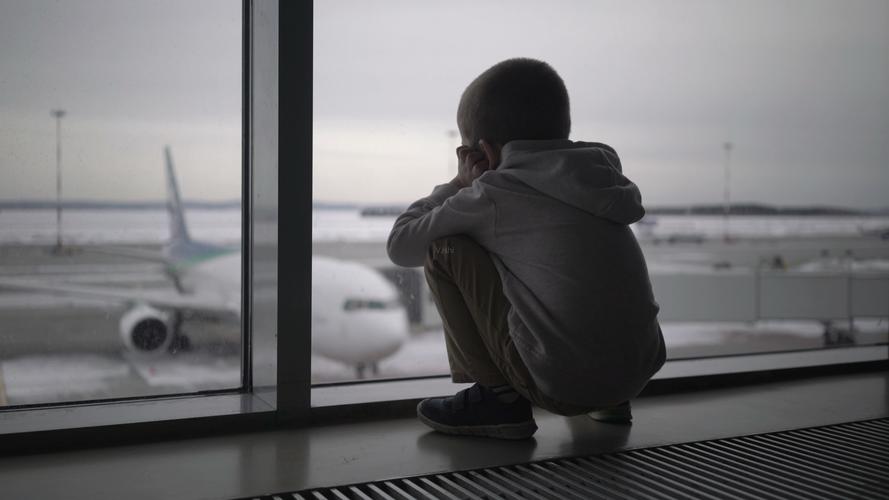 小男孩登在机场地上等人