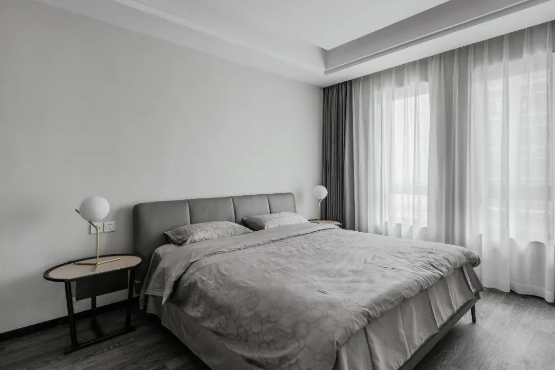 卧室以浅灰色的墙面空间搭配灰色窗帘床与床单带来一种简洁安静
