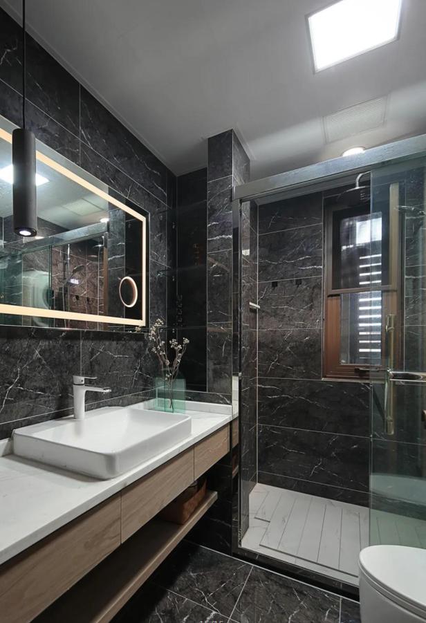 卫生间整体铺贴深色石纹瓷砖造型简洁颜色清淡的浴室柜与壁龛涵盖