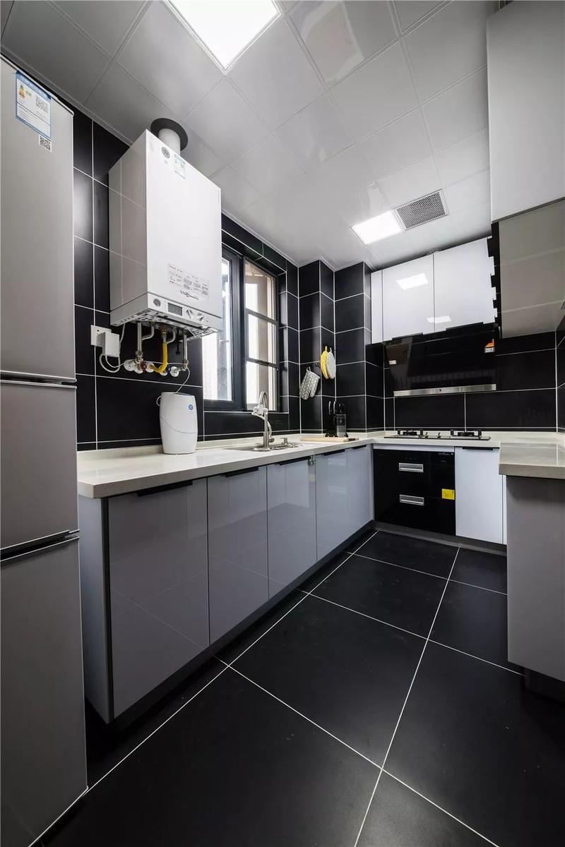 厨房选用深灰色的瓷砖和白色橱柜进行搭配让空间层次更加的丰富.
