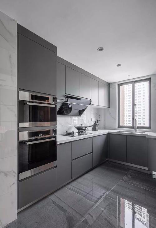厨房橱柜采用高级灰色柜体与白色石材台面搭配时尚的灰色地砖与爵士