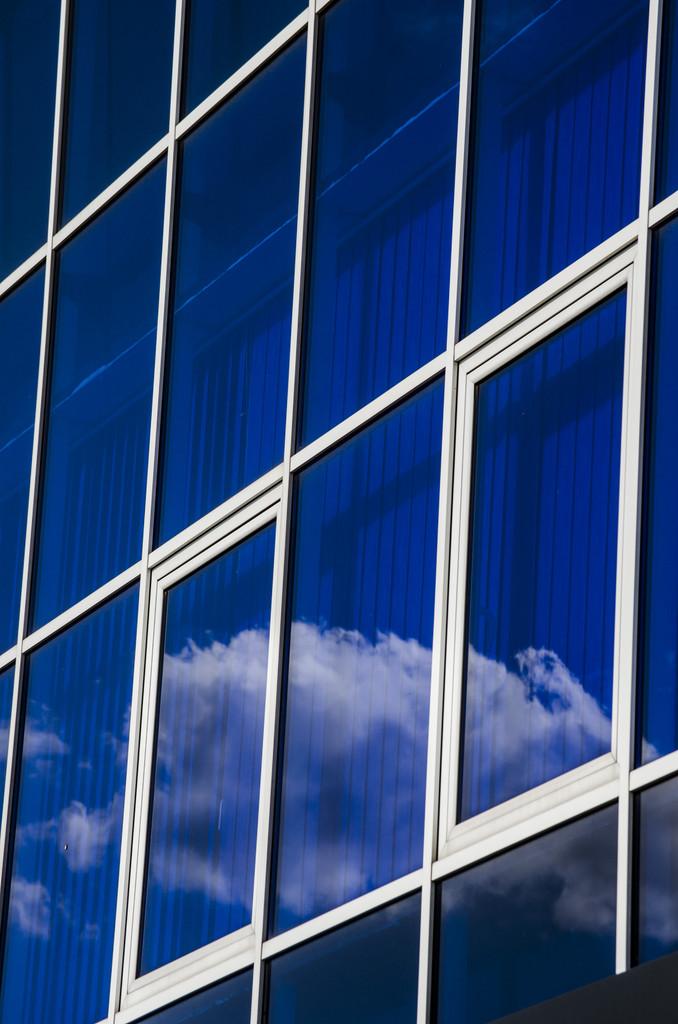 玻璃窗玻璃窗户用白色边框和背景为蓝色的窗帘.