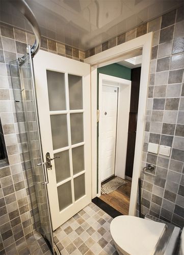 卫生间内灰色调格子的设计使得空间内充满了立体感玻璃隔断门设计