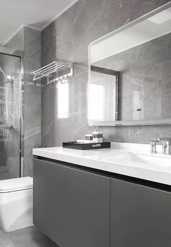 灰色的卫浴柜搭配白色的台面墙地面通铺灰色大理石纹路瓷砖整体低调