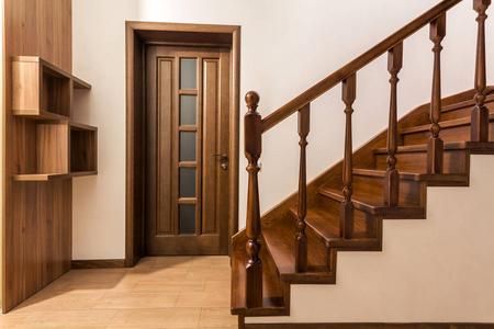 现代棕色橡木楼梯和门在新装修的房子照片