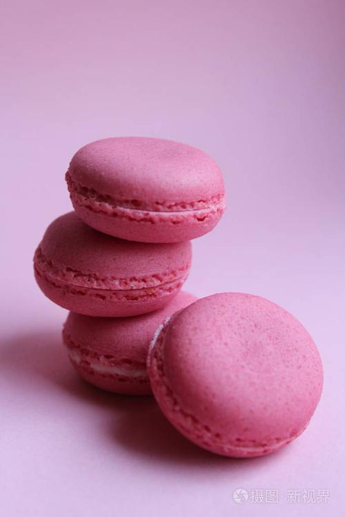 浅粉色背景下的四个粉红色马卡龙最低食品概念