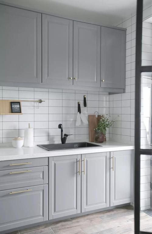 厨房地面拼贴木纹砖墙面采用文艺的白色瓷砖灰色橱柜金色拉手