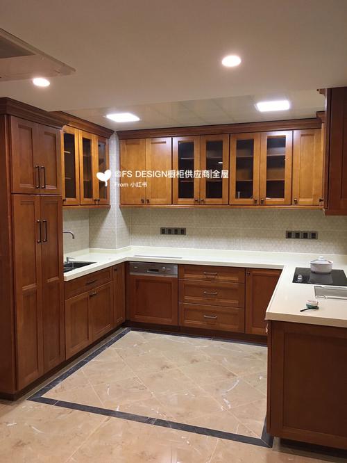 浅棕色调的实木橱柜以及门面上都有着纵横交错的自然肌理是厨房最