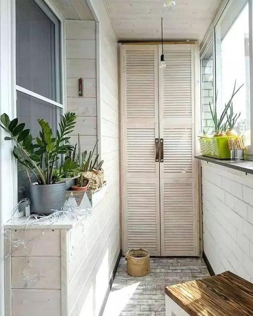 在狭小的阳台设置半高矮柜不显压迫柜子上方也能布置盆栽绿意.