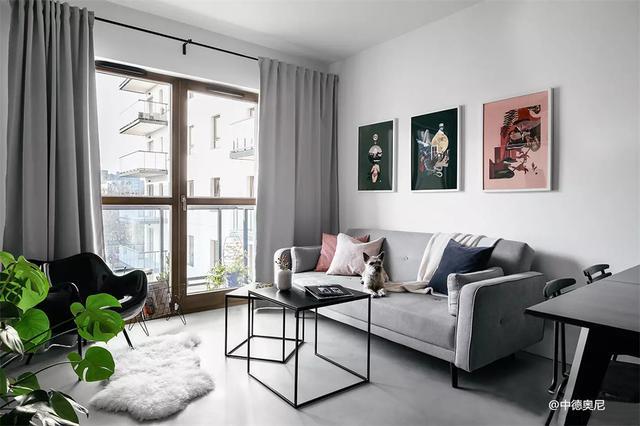 客厅大白墙搭配灰色的布艺沙发简单又大方沙发背景墙采用挂画装饰