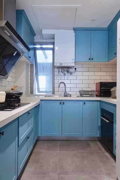 厨房的橱柜以优雅的蓝色面板搭配白色小块墙砖整体风格显得